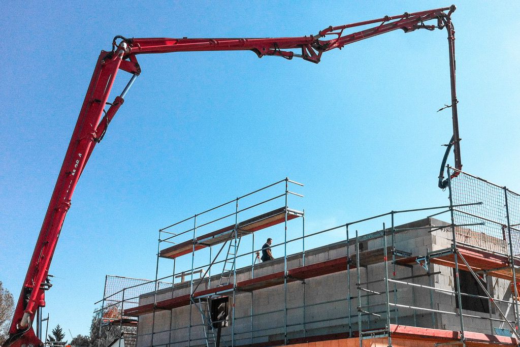 Kran bei Neubau eines Einfamilienhauses Kran transportiert Bauteil auf die Ebene eines Neubaus
